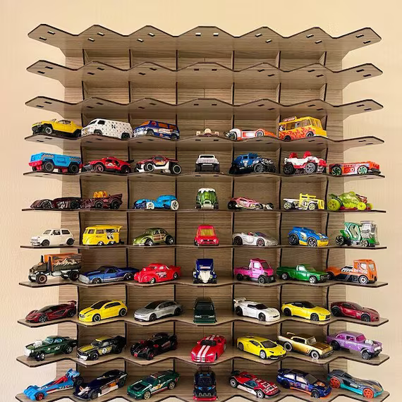 Large collection of colorful Hot Wheels and die-cast toy cars on a tiered wooden display shelf